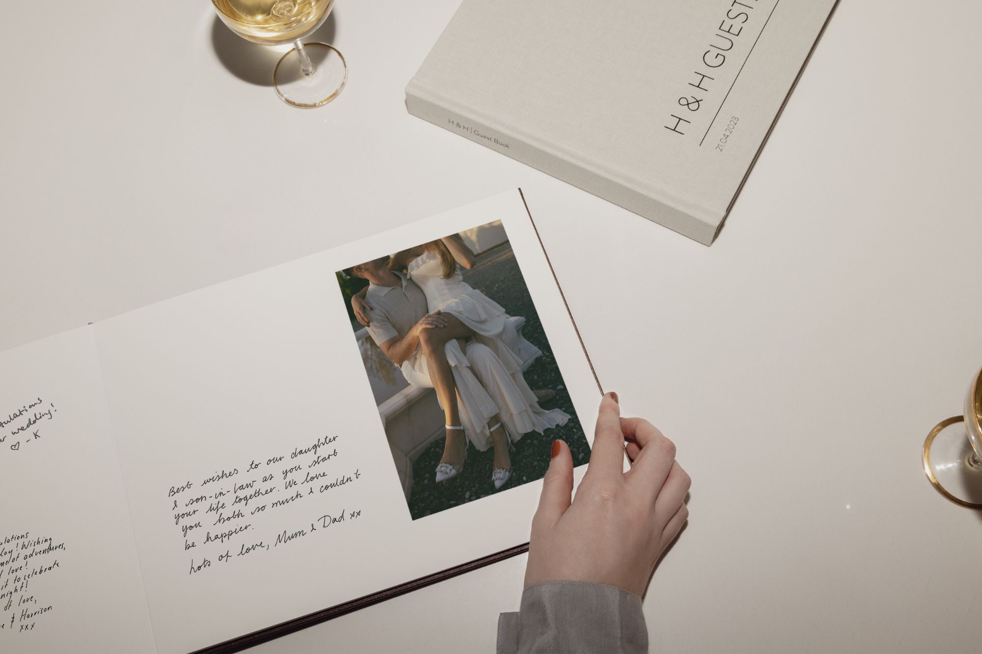 Hand flicking through page of a wedding guest book signed by family