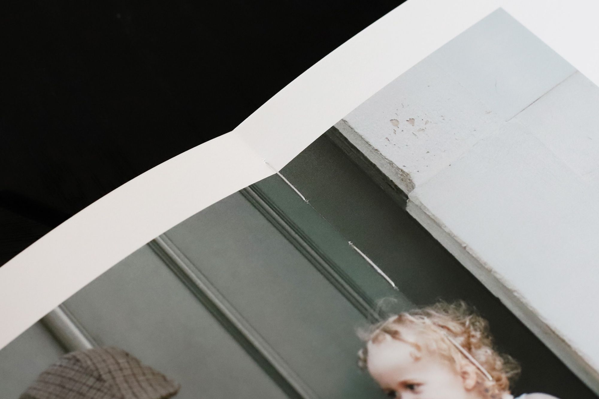 Close up of side of book with side of girls head and hat
