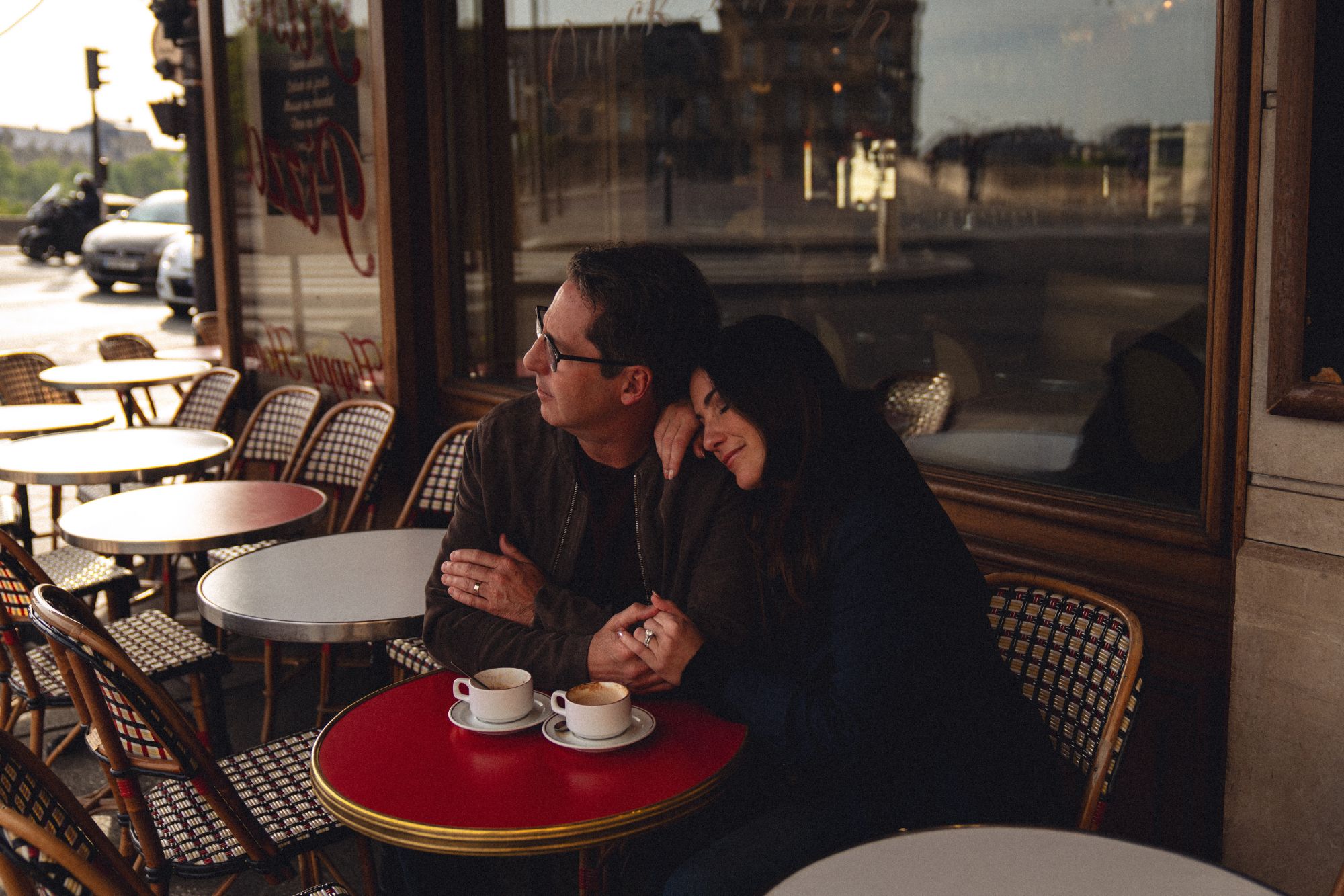 Couple sitting at a cafe table cuddling