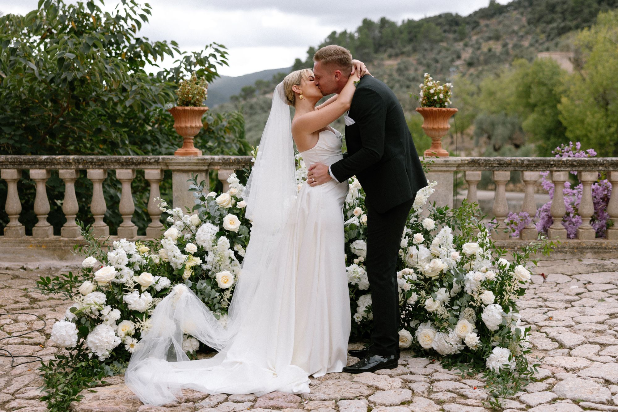 image of a couple kissing at wedding alter surrounded by flowers